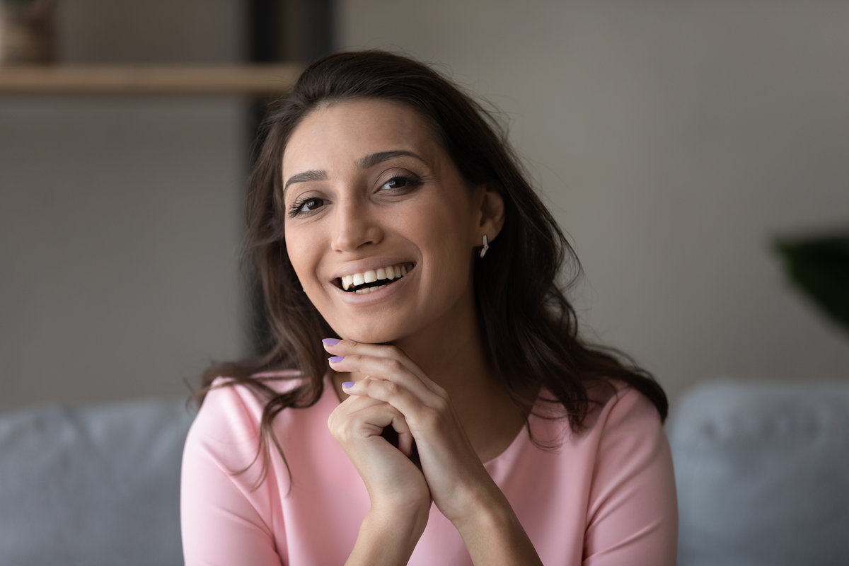 Head shot close up portrait of smiling beautiful young arabic indian mixed race ethnicity woman looking at camera, happy multiracial lady holding video web camera call online conversation at home.