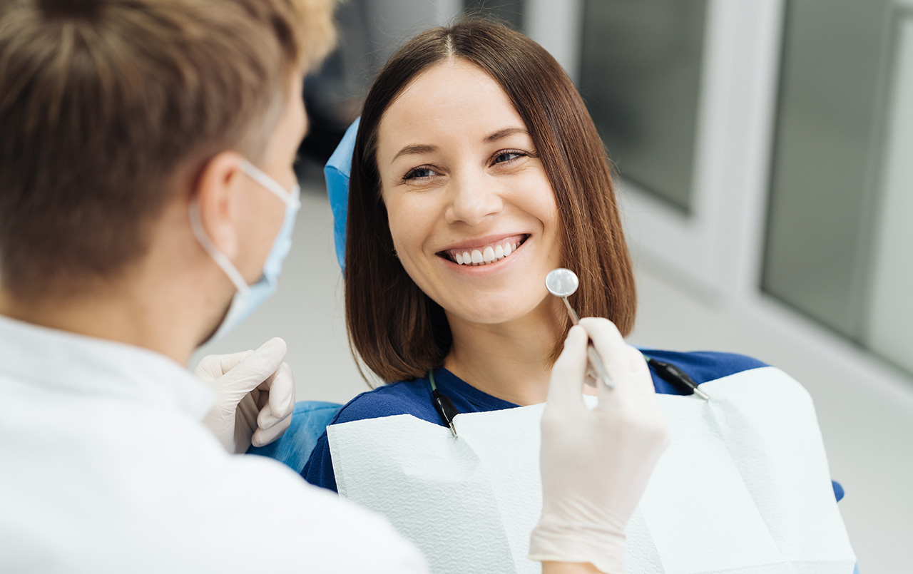 A smiling dark-haired girl in the dentist's chair