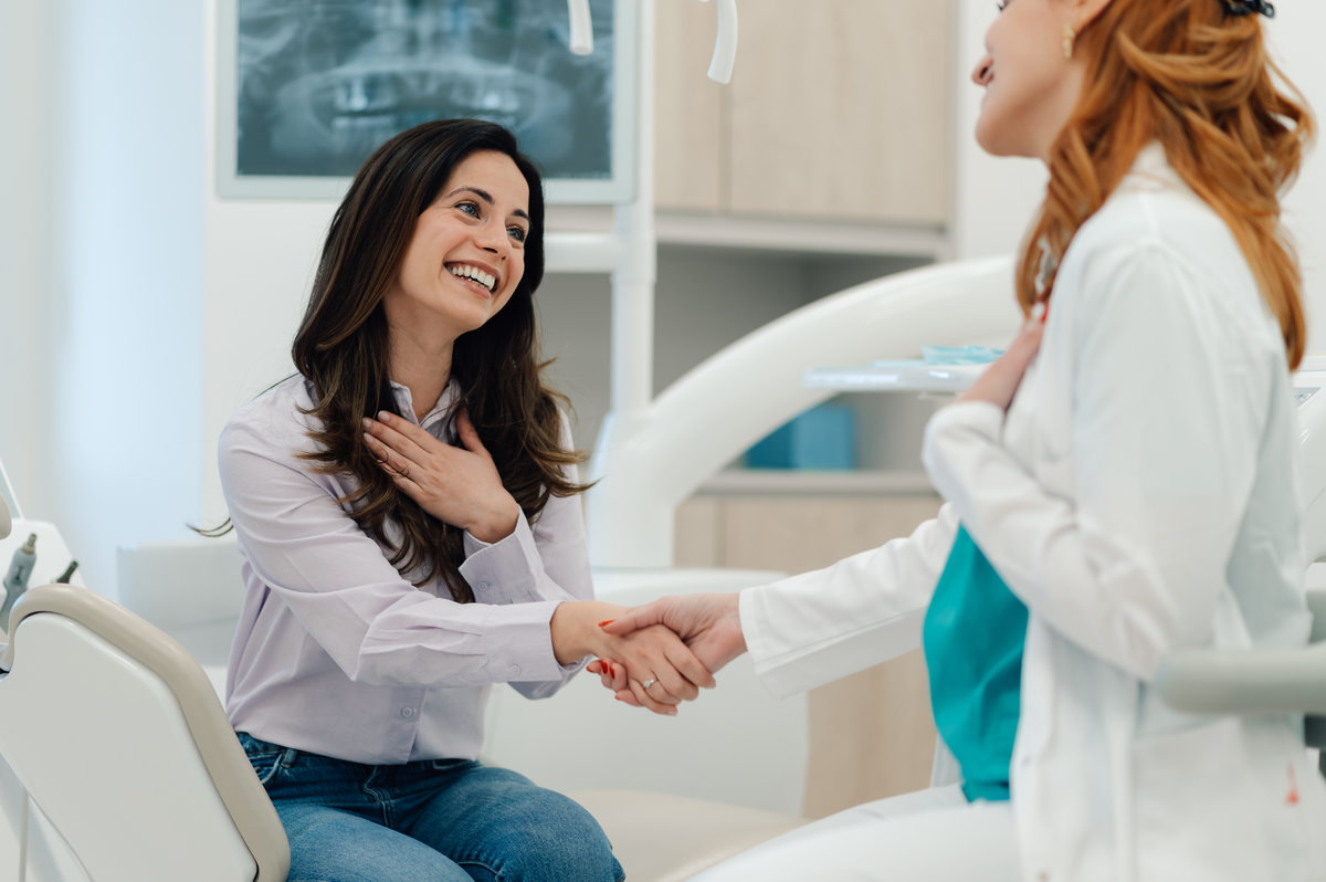 Grateful patient shaking dentist's hand after a successful dental checkup, expressing satisfaction and trust in the dental clinic's services