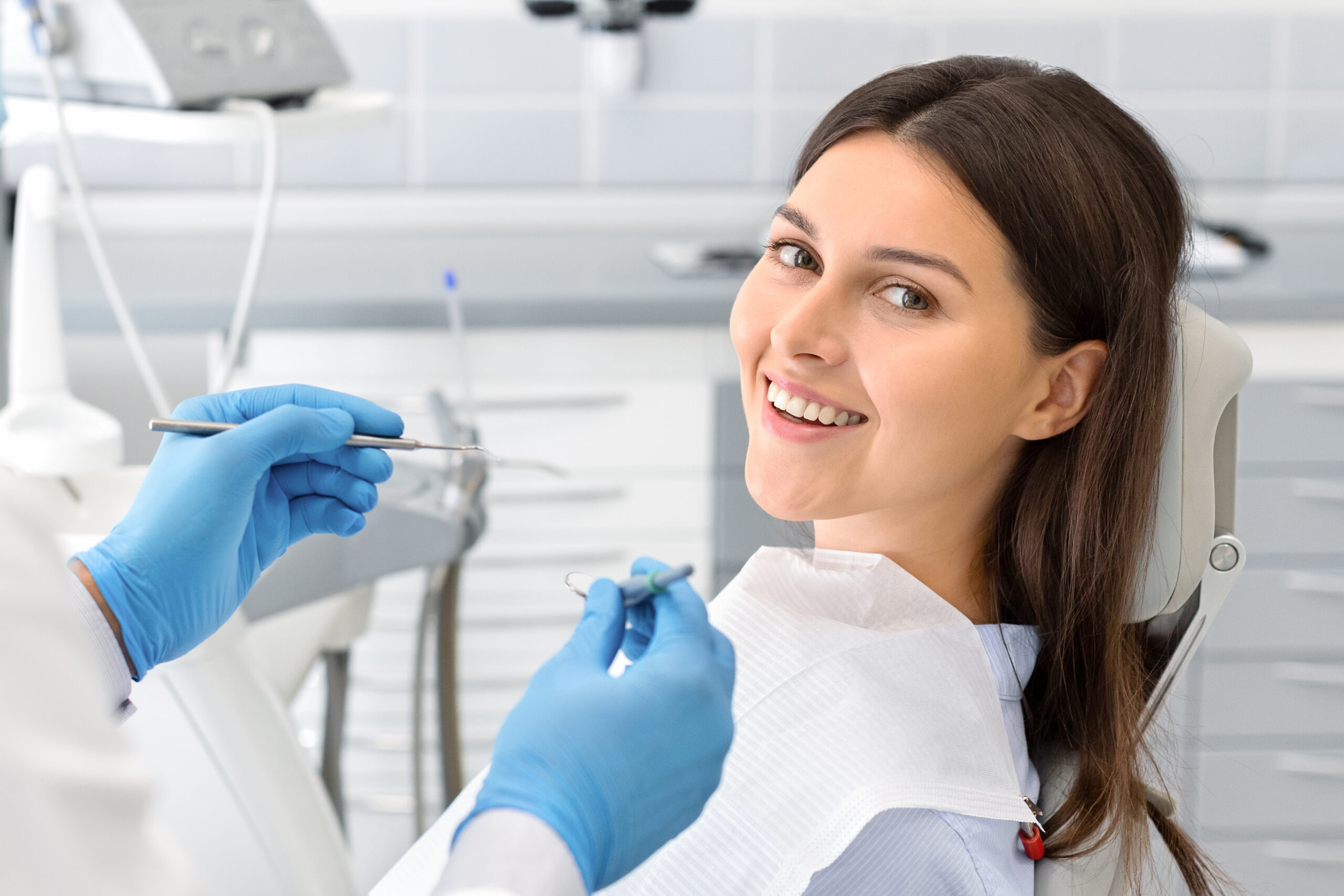 Portrait of young happy lady sitting in dentist chair
